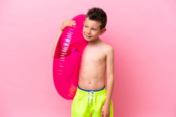 Little Caucasian Boy Holding Inflatable Donut Isolated Pink Background Looking — Zdjęcie stockowe