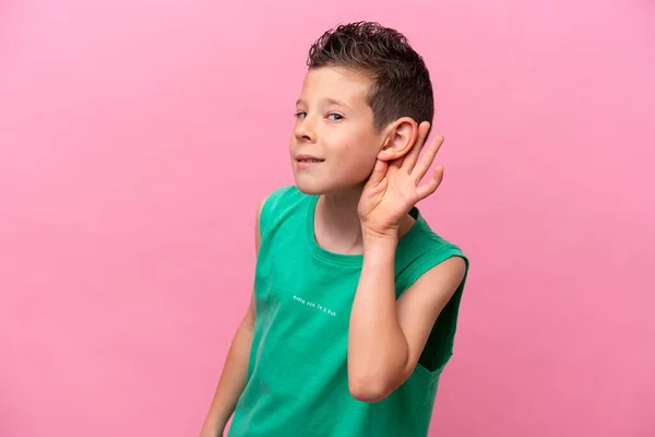 一个被粉色背景隔离的高加索小男孩 用手捂住耳朵听着什么 — 图库照片