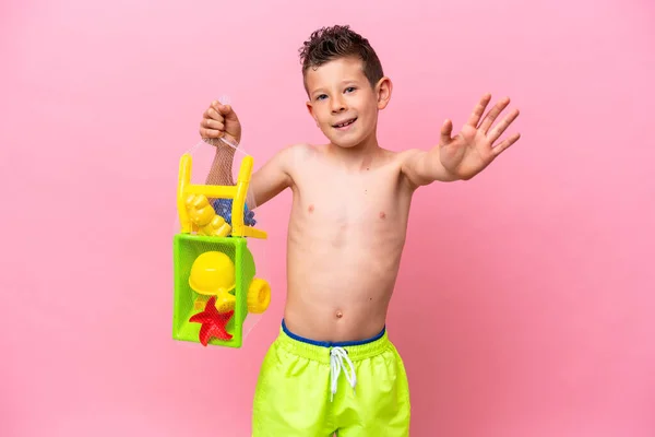 Kleiner Kaukasischer Junge Hält Strandspielzeug Isoliert Auf Rosa Hintergrund Und — Stockfoto