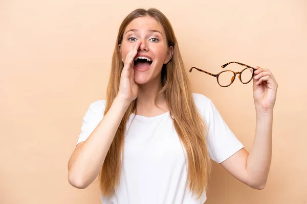 Ung Söt Blond Kvinna Med Glasögon Isolerade Beige Bakgrund Skrika — Stockfoto