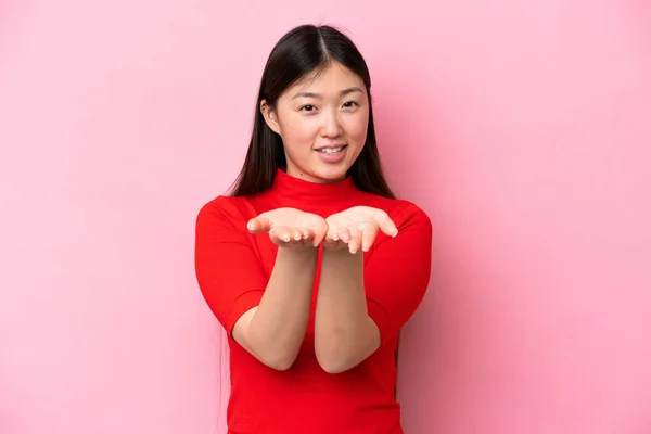 Молода Китайка Ізольована Рожевому Фоні Тримає Долоні Копіювальний Простір — стокове фото