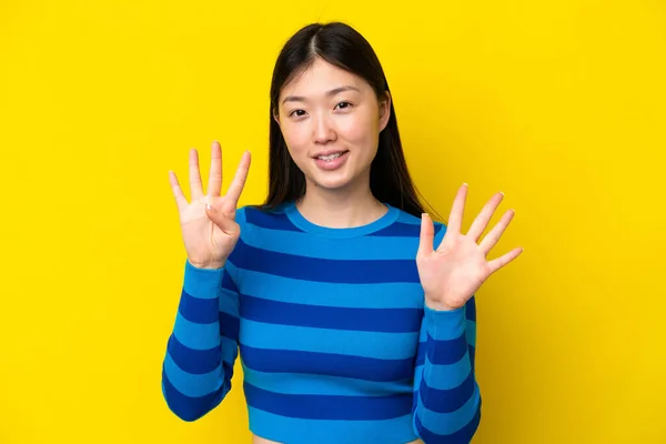 Sarı Arka Planda Izole Edilmiş Genç Çinli Kadın Parmaklarıyla Dokuz — Stok fotoğraf