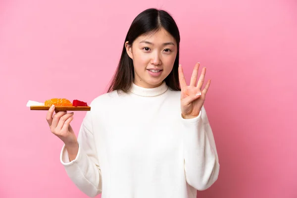 Молодая Китаянка Держит Сашими Изолированы Розовом Фоне Счастливы Подсчет Четырех — стоковое фото