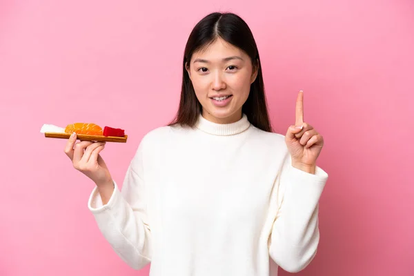 Молодая Китаянка Держит Сашими Изолированы Розовом Фоне Показывая Поднимая Палец — стоковое фото