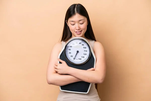 Young Chinese Woman Isolated Beige Background Weighing Machine — Foto Stock