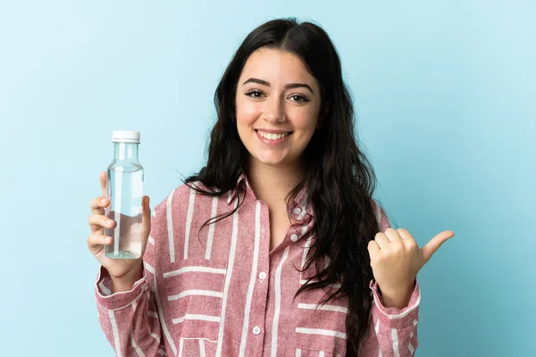 Jonge Vrouw Met Een Water Geïsoleerd Blauwe Achtergrond Wijzend Naar — Stockfoto