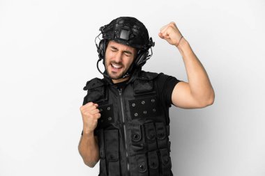 Beyaz arka planda izole edilmiş genç Kafkasyalı SWAT zaferi kutluyor.