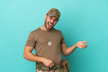 Mavi arka planda izole edilmiş künyeli ordu gitar hareketi yapıyor.