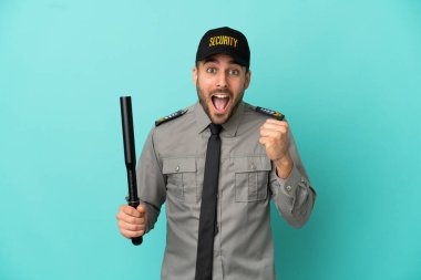 Genç güvenlik görevlisi mavi arka planda tek başına zaferi kutluyor.