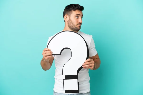 Young Handsome Caucasian Man Isolated Blue Background Holding Question Mark — Stockfoto