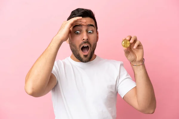 Young Man Holding Bitcoin Isolated Pink Background Doing Surprise Gesture — ストック写真