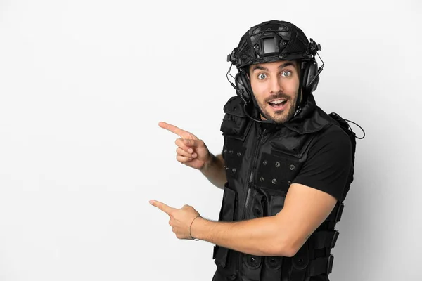 Young Caucasian Swat Isolated White Background Surprised Pointing Side — Φωτογραφία Αρχείου