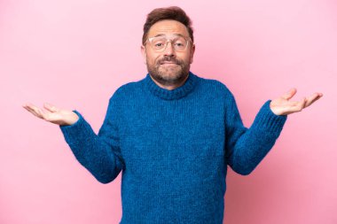 Pembe arka planda soyutlanmış orta yaşlı beyaz bir adam şüpheleri var.