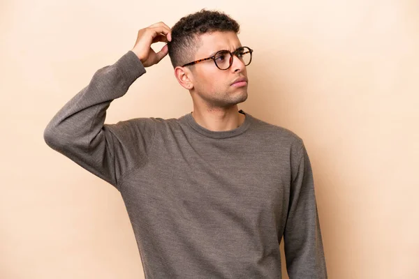 Young Brazilian Man Isolated Beige Background Having Doubts While Scratching — Photo