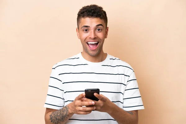 Young Brazilian Man Isolated Beige Background Surprised Sending Message — Zdjęcie stockowe