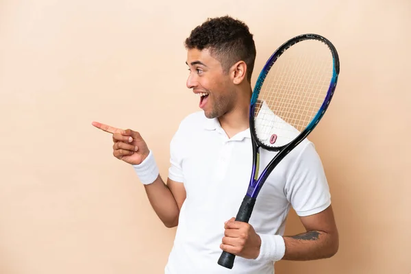 Young Brazilian Handsome Man Playing Tennis Isolated Beige Background Pointing — 스톡 사진