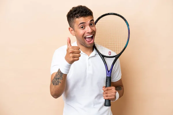 Молодий Вродливий Чоловік Грає Теніс Ізольований Бежевому Фоні Пальцями Вгору — стокове фото