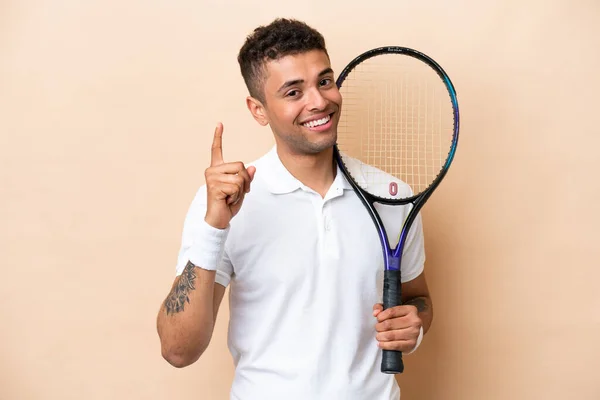 Молодий Вродливий Чоловік Грає Теніс Ізольований Бежевому Фоні Показує Піднімає — стокове фото