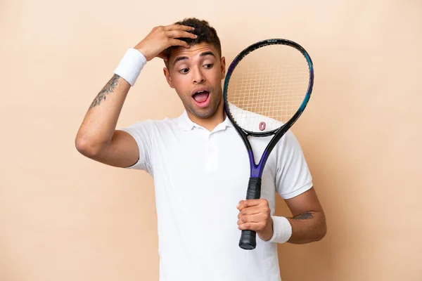 Молодий Вродливий Чоловік Грає Теніс Ізольований Бежевому Фоні Робить Несподіваний — стокове фото