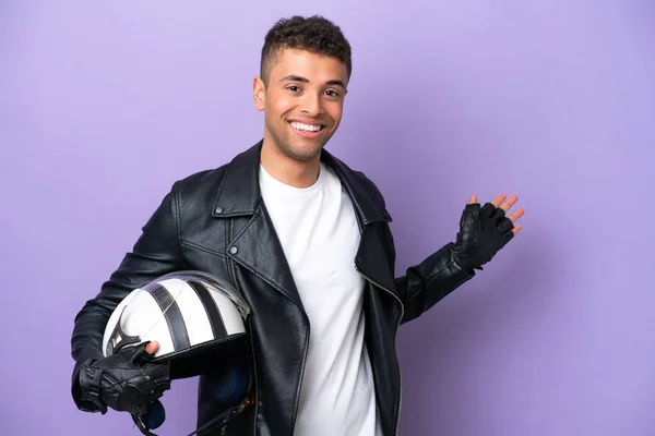 Молодой Бразилец Мотоциклетным Шлемом Изолирован Фиолетовом Фоне Протягивая Руки Сторону — стоковое фото