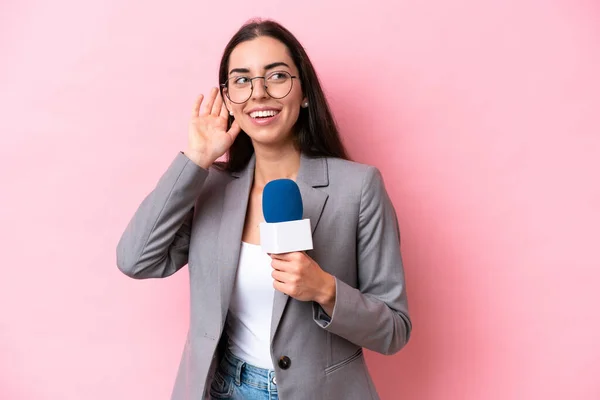 Joven Presentadora Televisión Caucásica Aislada Sobre Fondo Rosa Escuchando Algo — Foto de Stock