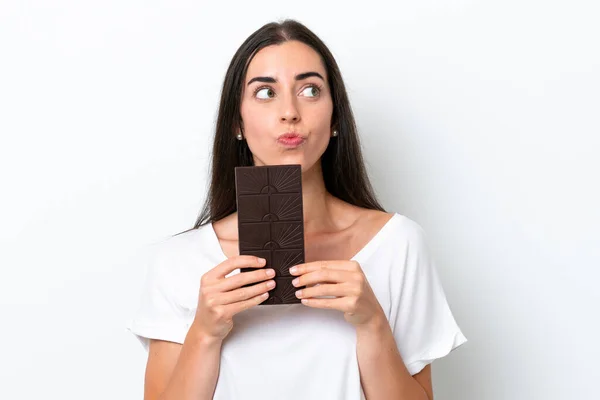 Mladá Běloška Žena Izolované Bílém Pozadí Čokoládovou Tabletu Mají Pochybnosti — Stock fotografie