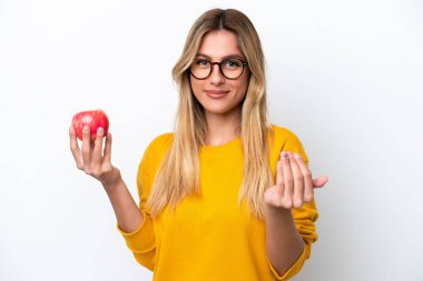 Beyaz arka planda soyutlanmış bir elmayla genç Uruguaylı kadın benimle gelmek için davet ediyor. Gelmene sevindim.