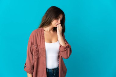 Kafkasyalı genç bir kadın mavi arka planda izole edilmiş. Şüpheleri var.