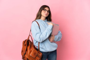 Pembe arka planda soyutlanmış, gururlu ve kendini beğenmiş genç bir bayan.