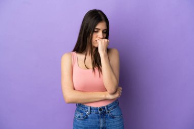 Mor arka planda izole edilmiş beyaz bir kadın. Şüpheleri var.