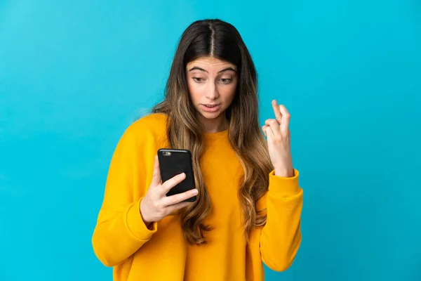 Junge Kaukasische Frau Isoliert Auf Blauem Hintergrund Mit Handy Mit — Stockfoto