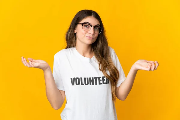 Mujer Joven Voluntaria Aislada Sobre Fondo Amarillo Que Tiene Dudas — Foto de Stock