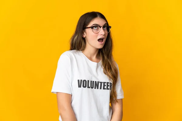 Mujer Joven Voluntaria Aislada Sobre Fondo Amarillo Mirando Hacia Arriba — Foto de Stock