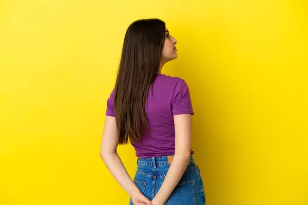 Mujer Joven Caucásica Aislada Sobre Fondo Amarillo Posición Espalda Mirando — Foto de Stock