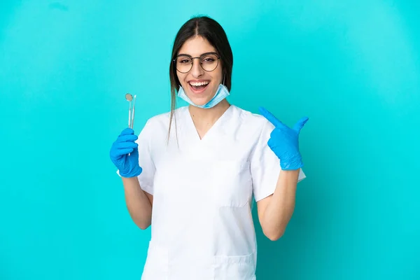 Junge Kaukasische Zahnärztin Die Werkzeuge Isoliert Auf Blauem Hintergrund Hält — Stockfoto