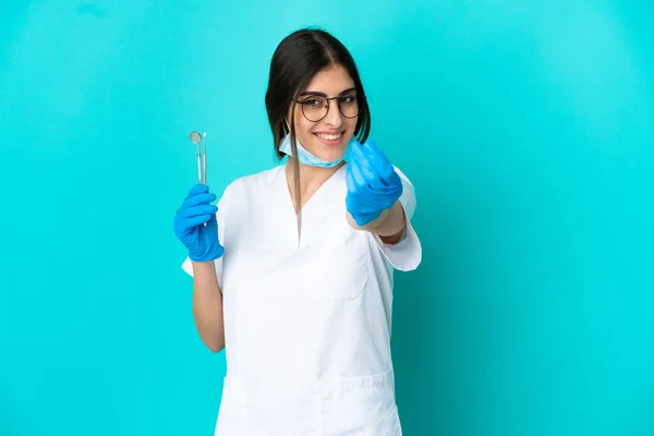 Junge Kaukasische Zahnärztin Frau Mit Werkzeugen Isoliert Auf Blauem Hintergrund — Stockfoto