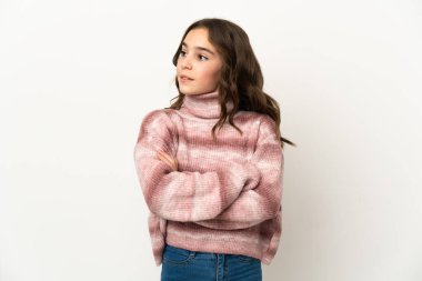 Beyaz arka planda izole edilmiş küçük beyaz kız yan tarafa bakıyor.