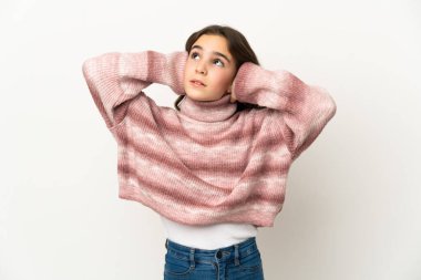 Beyaz arka planda izole edilmiş küçük beyaz kız hayal kırıklığına uğramış ve kulaklarını kapatmış.