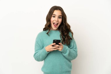 Beyaz arka planda izole edilmiş küçük beyaz kız şaşırdı ve bir mesaj gönderiyor.