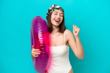 Mavi arka planda hava yatağı tutan genç Ukraynalı kadın zaferi kutluyor.