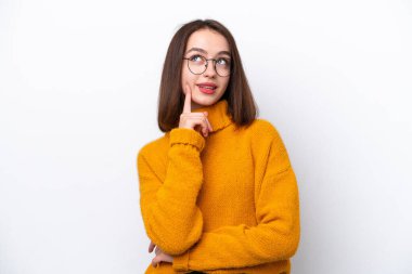 Genç Ukraynalı bir kadın beyaz arka planda izole edilmiş bir şekilde yukarı bakarken bir fikir düşünüyor.