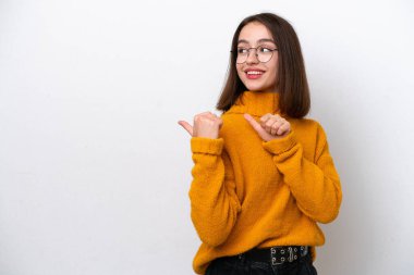 Beyaz arka planda izole edilmiş genç Ukraynalı kadın bir ürünü sunmak için kenarı işaret ediyor