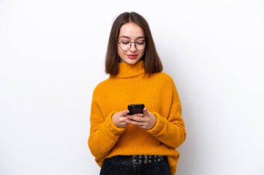 Beyaz arka planda izole edilmiş genç Ukraynalı kadın cep telefonuyla mesaj gönderiyor.