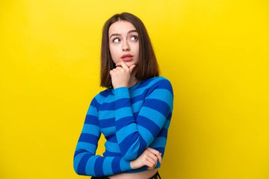 Sarı arka planda izole edilmiş genç Ukraynalı kadının şüpheleri var.