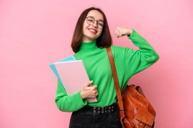 Genç öğrenci Ukraynalı kadın pembe arka planda izole edilmiş güçlü bir jest yapıyor.