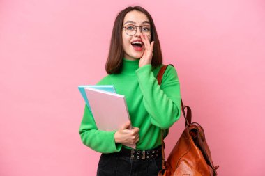 Genç öğrenci Ukraynalı kadın pembe arka planda izole edilmiş, şaşırmış ve şok olmuş bir yüz ifadesi var.