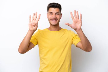 Beyaz arka planda izole edilmiş beyaz tenli genç dokuz parmaklı sayıyor.