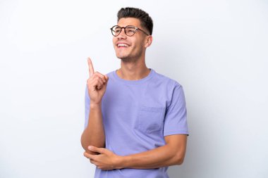 Beyaz arka planda izole edilmiş genç beyaz adam harika bir fikre işaret ediyor