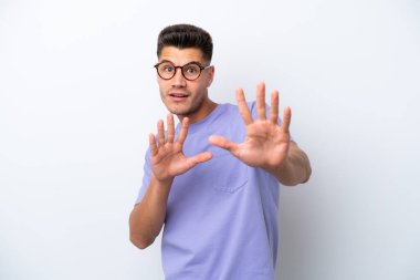 Beyaz arka planda izole edilmiş genç beyaz bir adam sinirleri gergin ve ellerini öne uzatıyor.