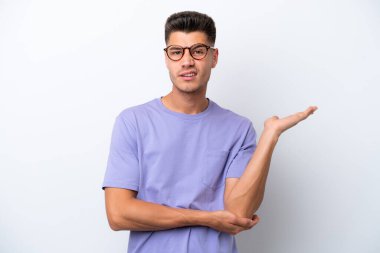 Beyaz arka planda soyutlanmış genç beyaz bir adamın şüpheleri var.